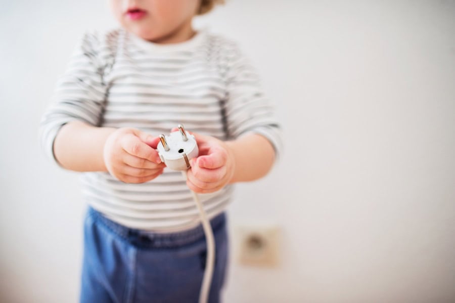 Electricity—How to Stay Safe. Toddler boy in a dangerous situation at home.