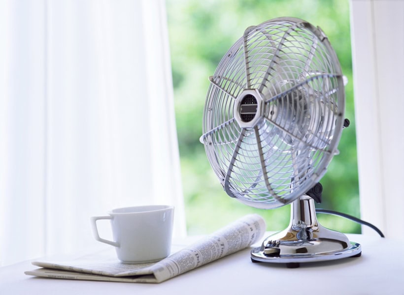 electric fan improving indoor air quality next to a newspaper